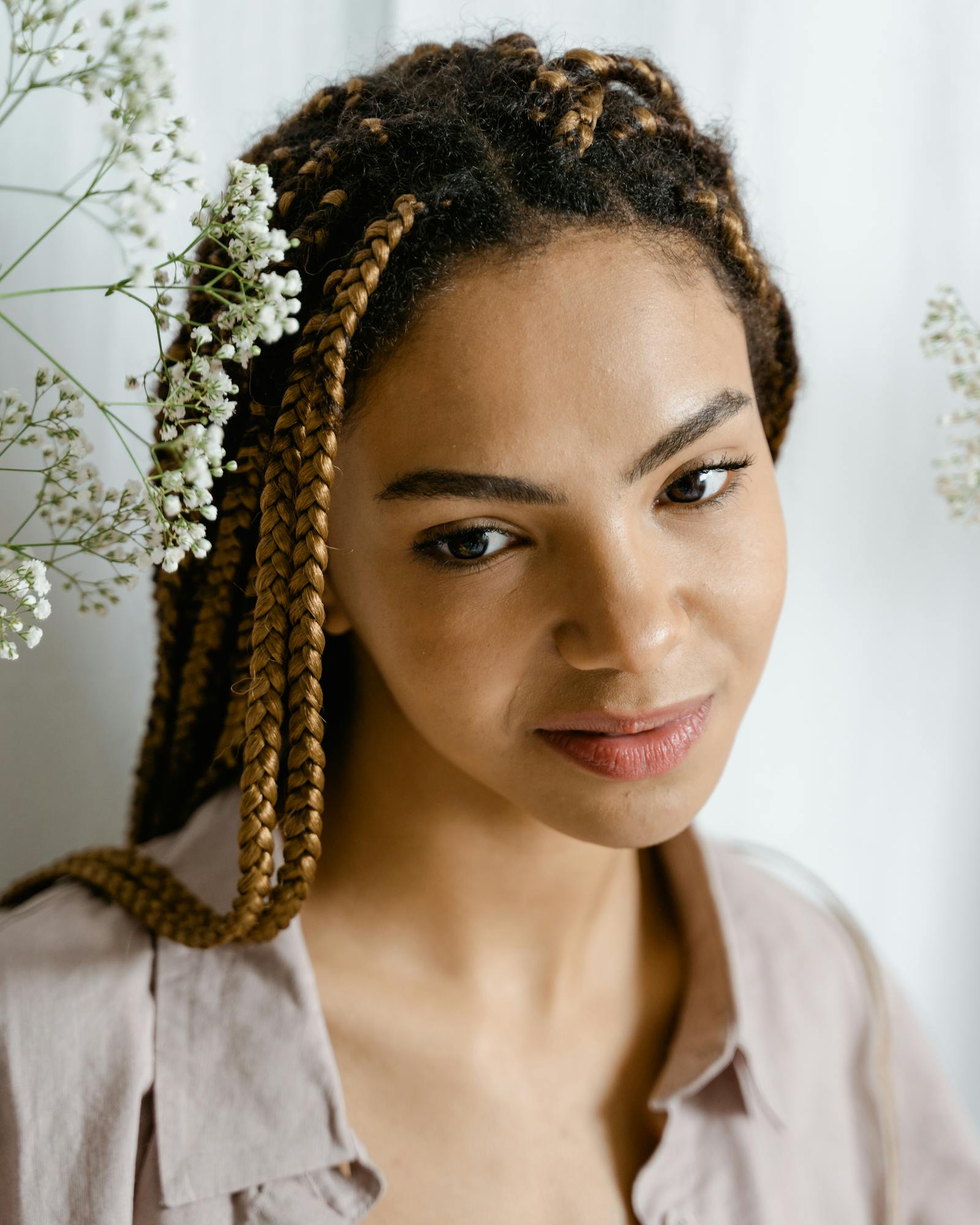 A client with honey braids beside baby's breath